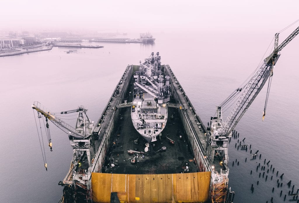 Ship in a dry dock with cranes alongside
